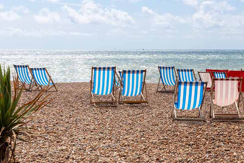 Colorful Striped Empty Deck Chairs On Brighton Beach, England