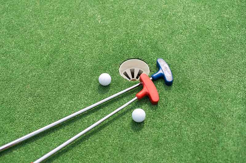 fun things to do in hocking hills Mini-golf clubs and balls of different colors laid on artificial grass