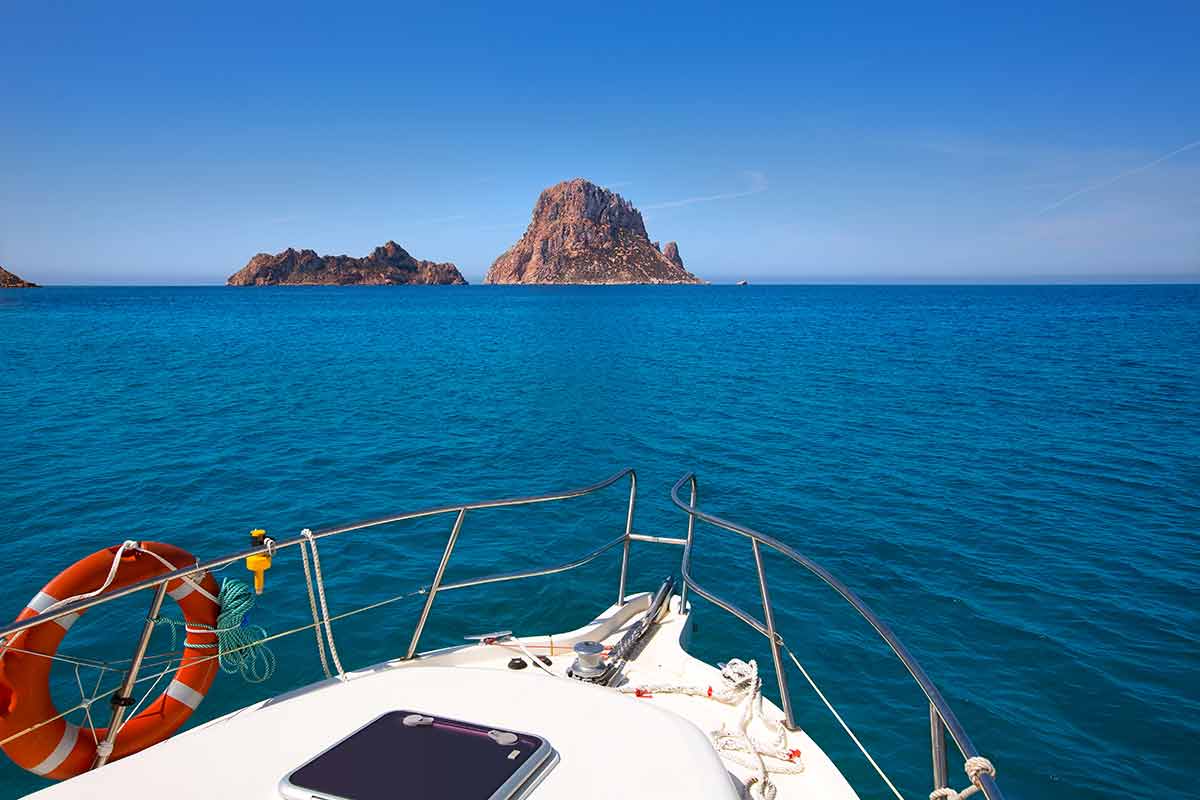 fun things to do in ibiza island front of a boat pointing towards Es Vedra