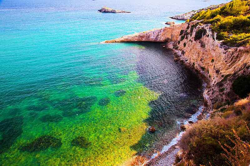 fun things to do in ibiza cove with clear emerald water from above