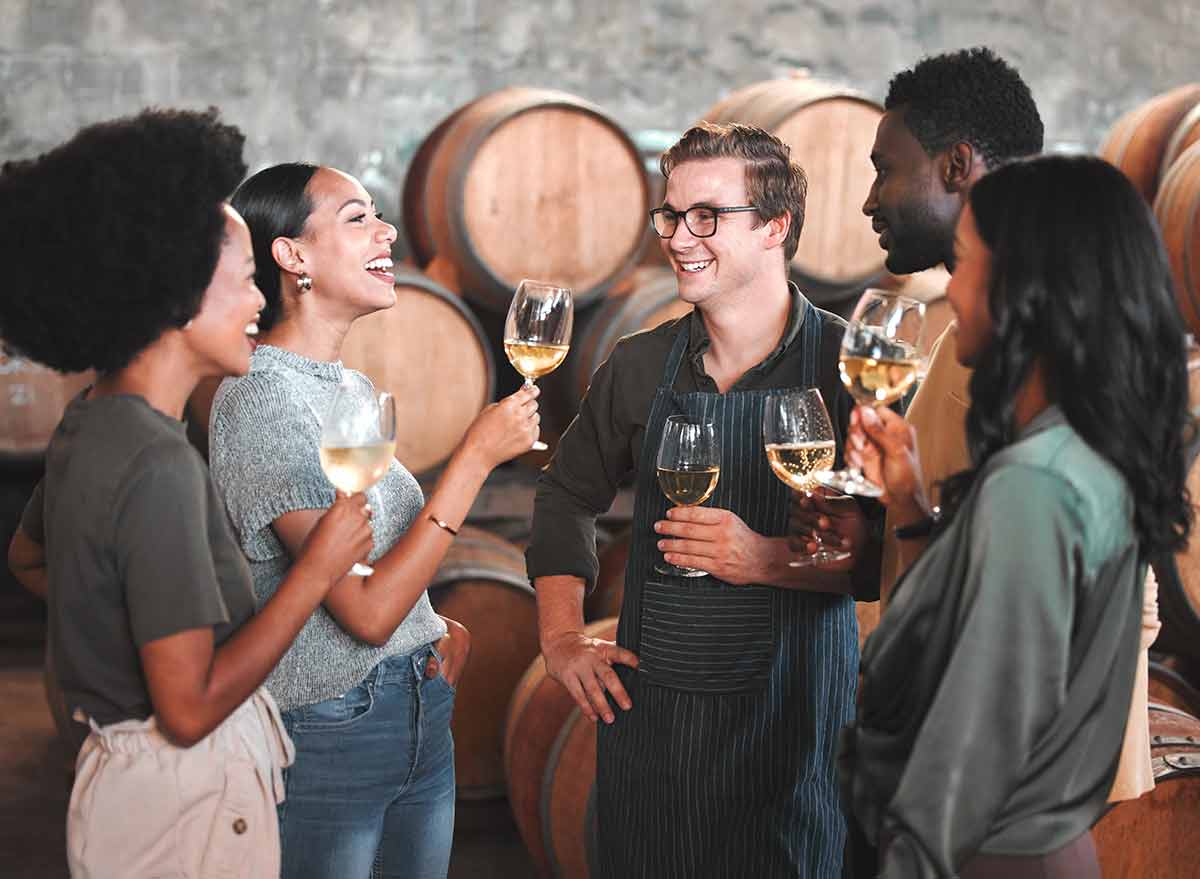 fun things to do in kansas city missouri for adults Group of friends wine tasting at a distillery or cellar drinking glasses and enjoying the tour together.