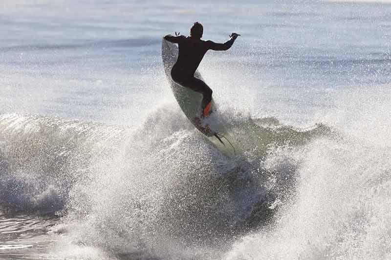 fun things to do in manhattan beach surfer riding a wave