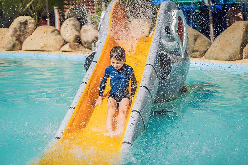 fun things to do in mazatlan boy sliding down a yellow water slide