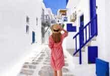 fun things to do in mykonos greece Traveler girl walks through the alleys in Mykonos picturesque town in Greece