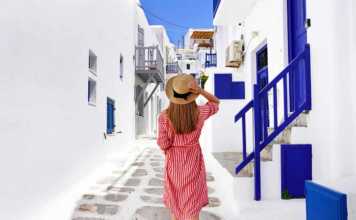 fun things to do in mykonos greece Traveler girl walks through the alleys in Mykonos picturesque town in Greece
