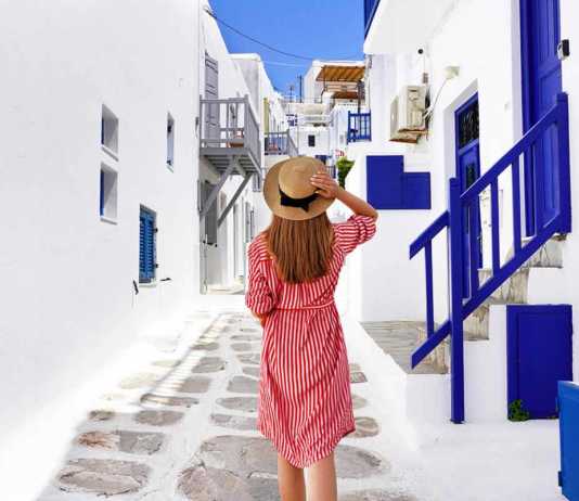 fun things to do in mykonos greece Traveler girl walks through the alleys in Mykonos picturesque town in Greece