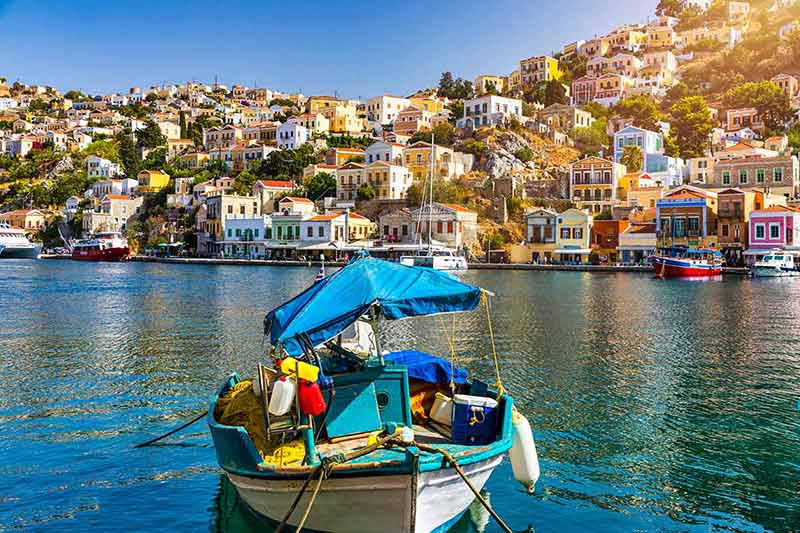 fun things to do in rhodes island View of the beautiful greek island of Symi (Simi) with colourful houses and small boats.