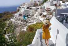 Young beautiful girl walking in Oia village on Santorini Island, Greece.