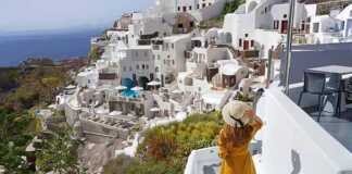 Young beautiful girl walking in Oia village on Santorini Island, Greece.