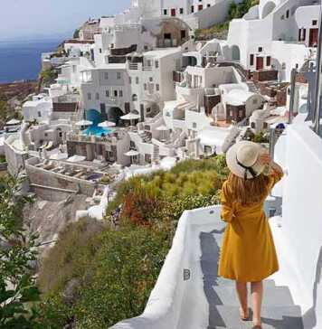 Young beautiful girl walking in Oia village on Santorini Island, Greece.