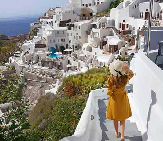 Young beautiful girl walking in Oia village on Santorini Island, Greece.