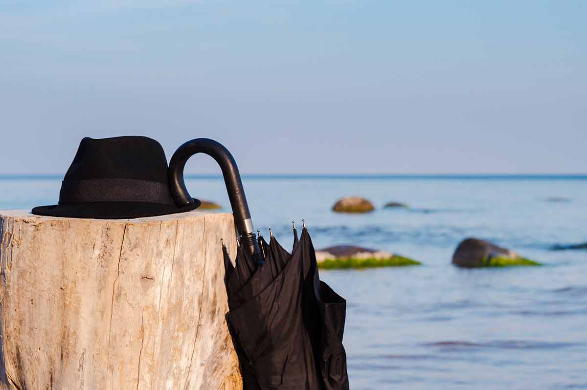 hamptons new york beaches Black umbrella and hat on the wooden stump at the seashore