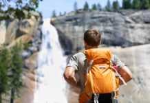 20 California Waterfalls That Will Leave You Speechless hiking trails with waterfalls in california Hiker hiking with backpack looking at waterfall in Yosemite park in beautiful summer nature landscape