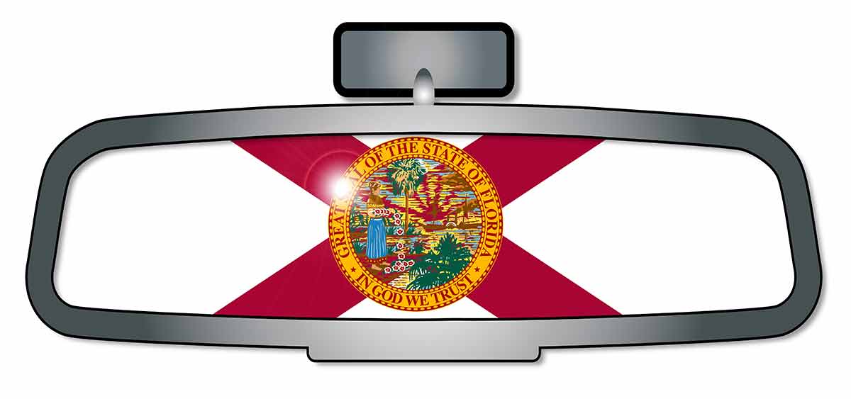A vehicle rear view mirror with the flag of the state of Florida.
