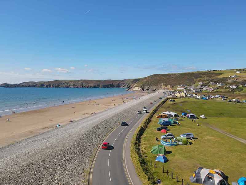 how many beaches are there in wales Newgale Beach stunning ocean views from the coast with a light blue sea and a nearby camp site.