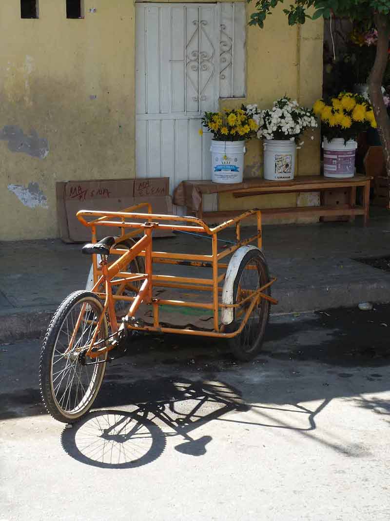 A three-wheeled delivery bike outside a house in the town of Huatulco Crucecita