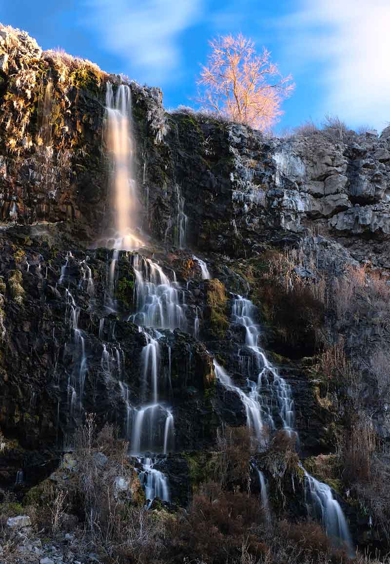 High waterfall trickling down rock face in thousand springs