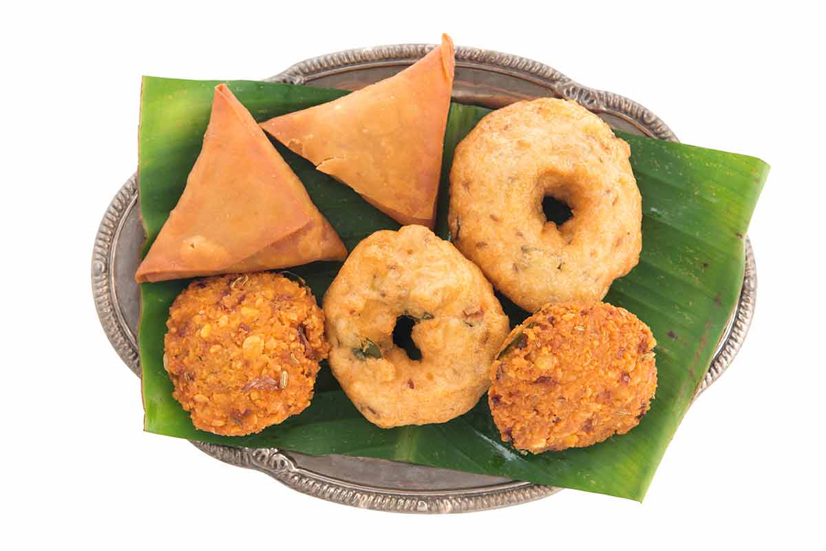 indian street food near me platter of six snacks on a pandan leaf