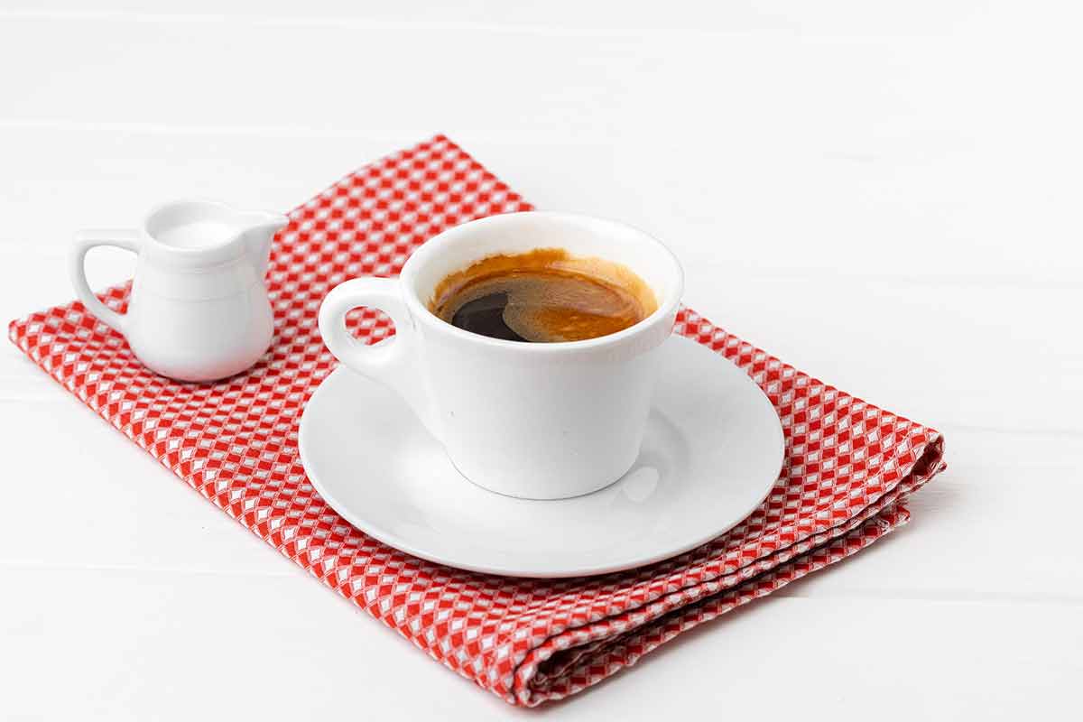 italian coffee drinks red checked table cloth, white coffee cup and milk