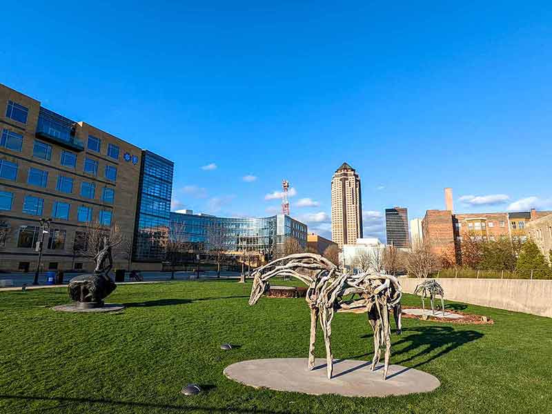sculptures of horses and other art on a green lawn in Des Moines