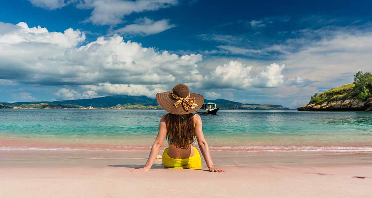 a woman sitting on pink beach Komodo Island