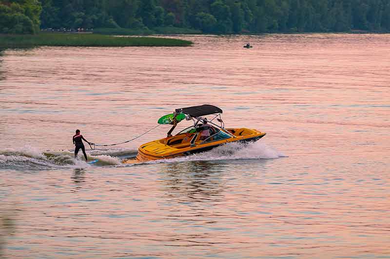 A Boat Pulls A Person Over The Waves