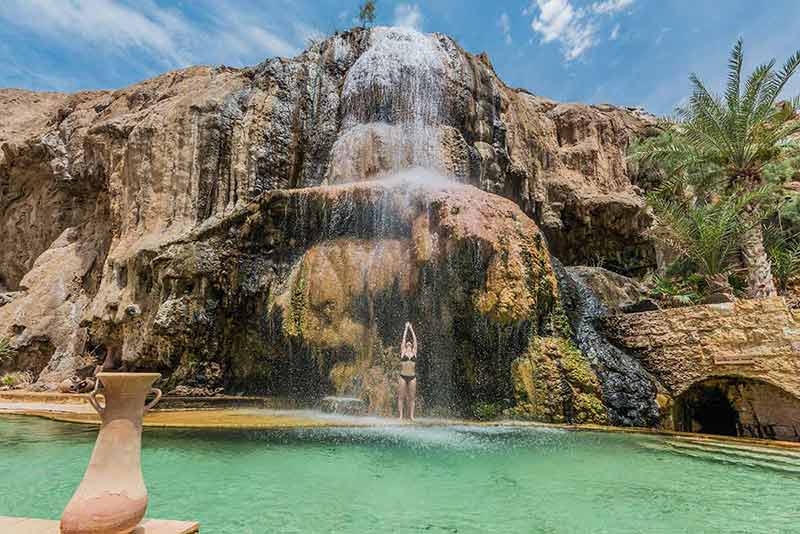 landmarks in jordan one woman bathing at ma'in hot springs waterfall