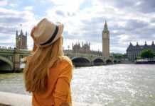 london in summer Back view of traveler girl enjoying sight of Westminster bridge and palace on River Thames with famous Big Ben tower in London, UK.