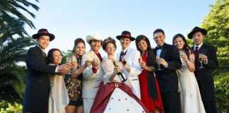 mexican quinceanera traditions - group of young people dressed up in finery holding champagne flasses