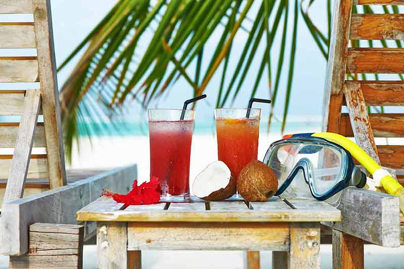 cocktails, coconuts and snorkel mask on a beach