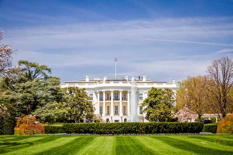 national landmarks in washington dc The White House front view with blue sky and green lawn