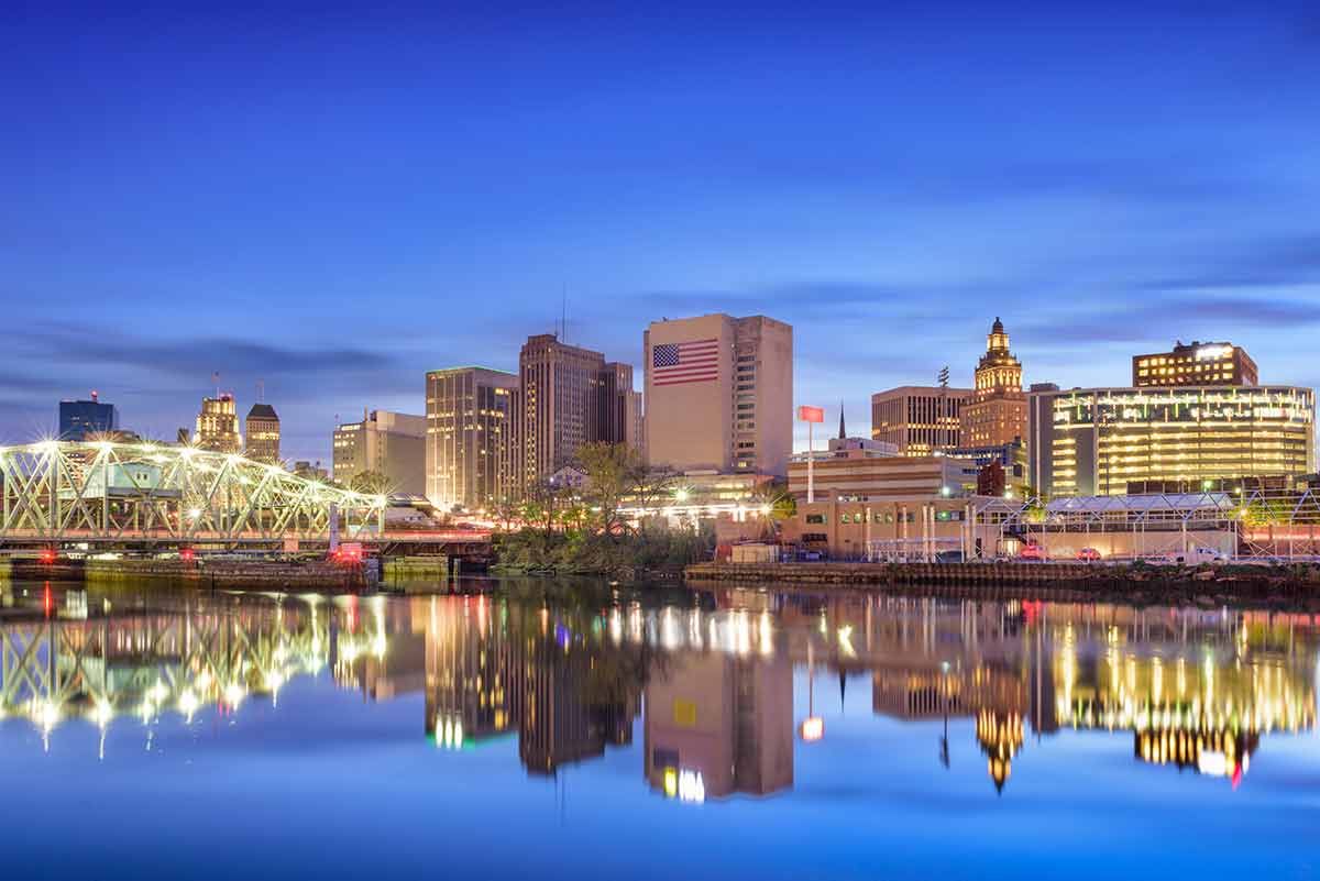 buildings in newark at night reflected in the water