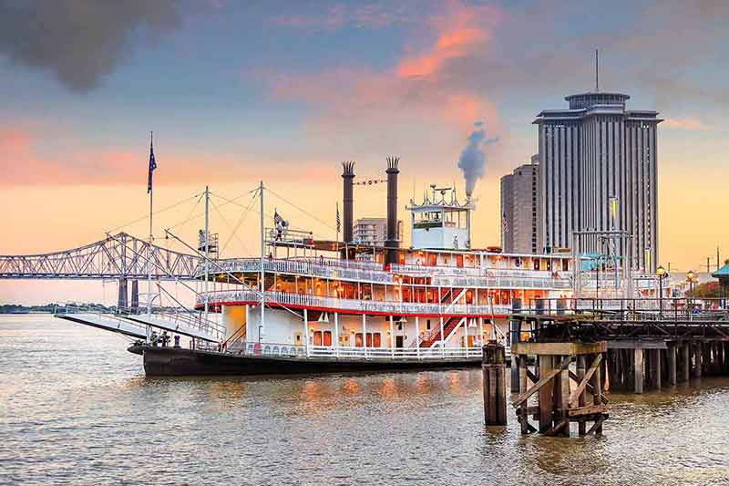new orleans skyline at night paddle steamer on the Mississippi River with buildings in the background