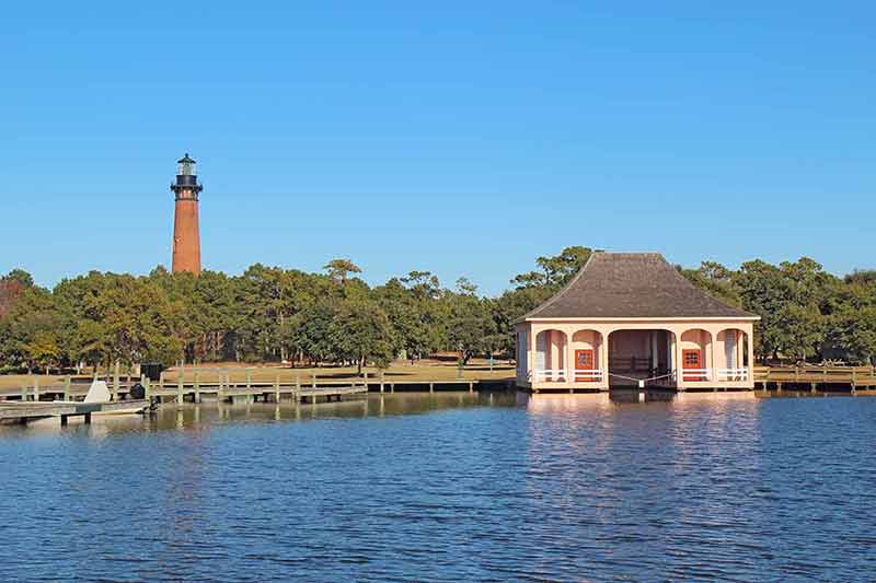 nicest beaches in north carolina red brick structure of the Currituck Beach Lighthouse and the pink boathouse