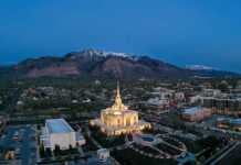 20 things to do in Ogden Utah that will completely surprise you ogden utah aerial view with Mormon temple lit up and snowcapped mountains in the background.