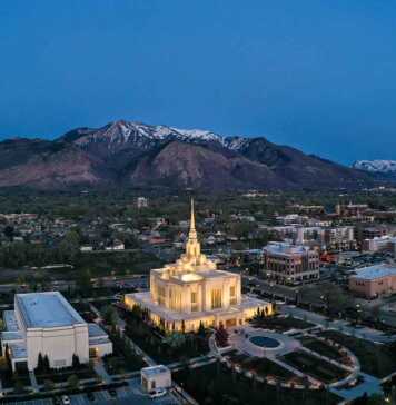 20 things to do in Ogden Utah that will completely surprise you ogden utah aerial view with Mormon temple lit up and snowcapped mountains in the background.