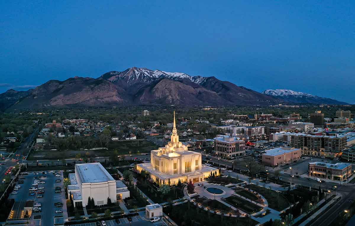 ogden utah aerial view with Mormon temple lit up and snowcapped mountains in the background.