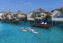 staff floating past palafitos overwater bungalow mexico