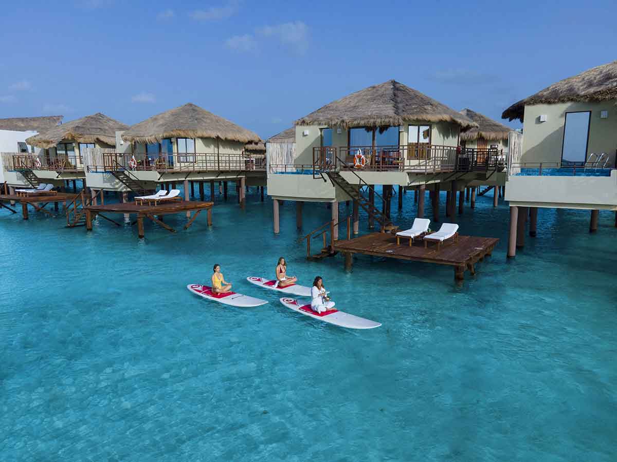 staff floating past palafitos overwater bungalow mexico