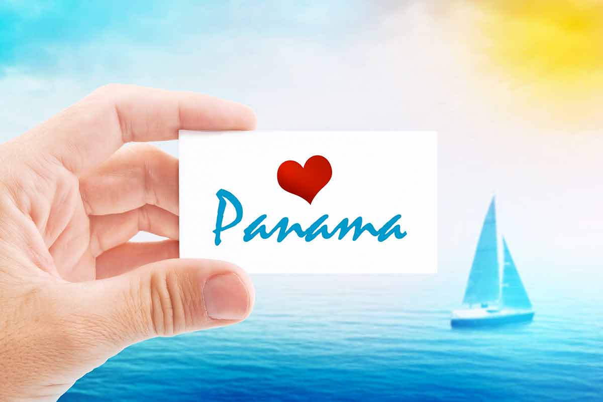 panama beaches hand holding a card with a red heart and the world panama