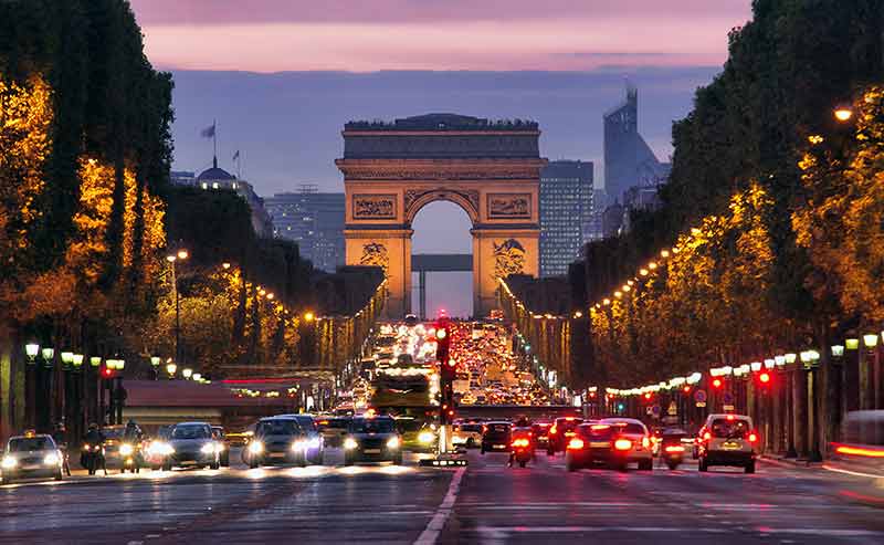 paris street scene at night Avenue Champs Elysees with Arc de Triomphe at the end