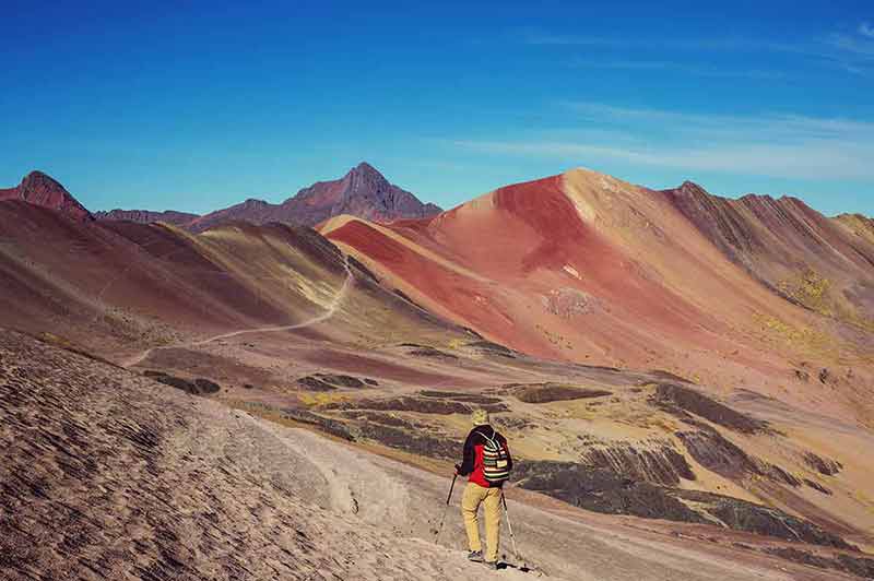 hiker at the foot of Rainbow Mountain