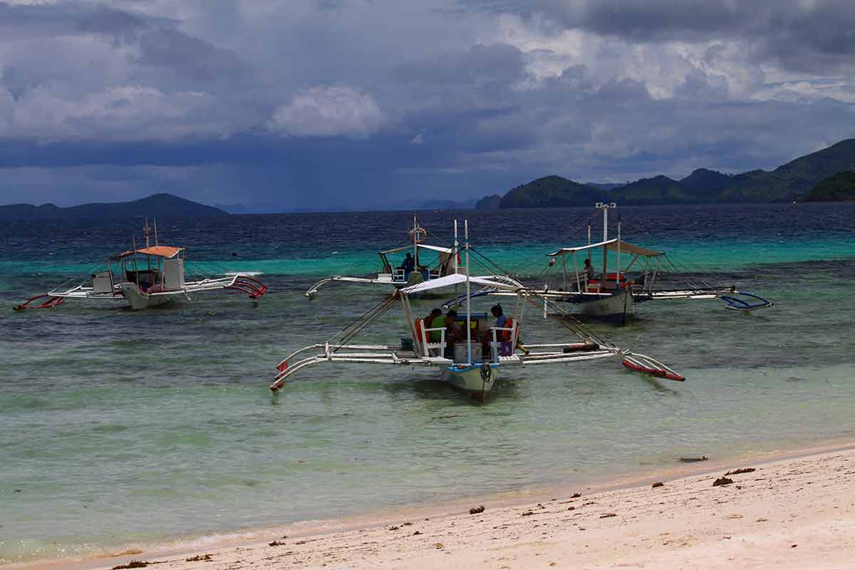 philippines beaches local boats moored at the beach at Coron