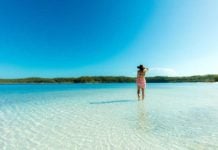 40 Queensland Experiences Every Aussie Should Have At Least Once woman standing in Lake Mackenzie, one of the amazing places to visit in queensland