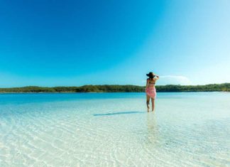 40 Queensland Experiences Every Aussie Should Have At Least Once woman standing in Lake Mackenzie, one of the amazing places to visit in queensland