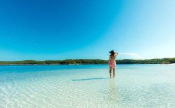 woman standing in Lake Mackenzie, one of the amazing places to visit in queensland