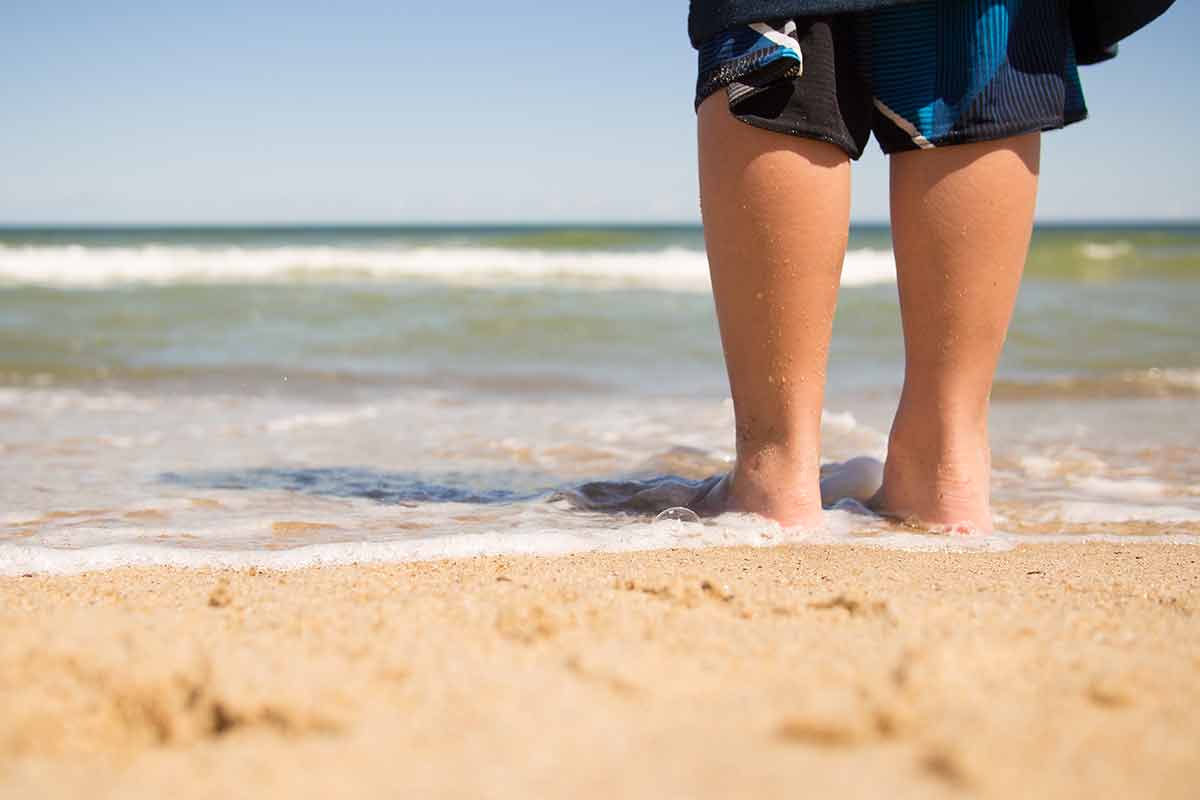 public beaches in massachusetts Boy standing on the beach and relaxing in Cape Cod