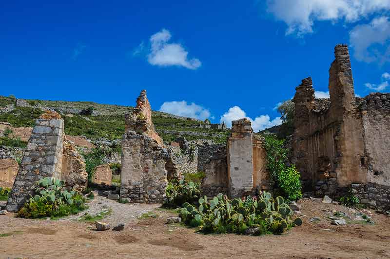 realde catorce ruins with blue sky and cactii around it