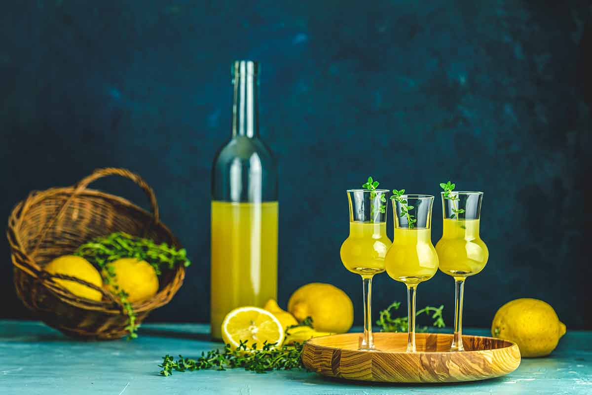 san pellegrino italian sparkling drinks Limoncello with thyme in three grappas wineglass in wooden tray,