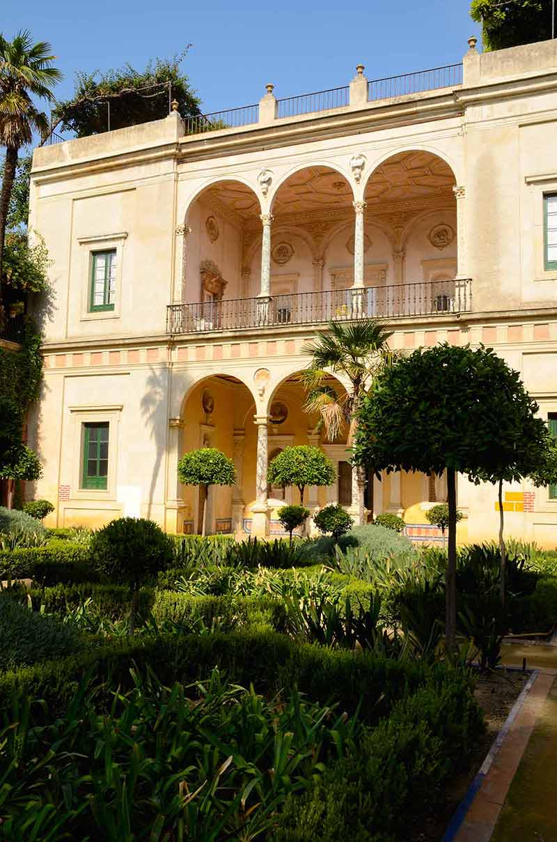 seville things to do in 2 days yellow facade of the house and gardens